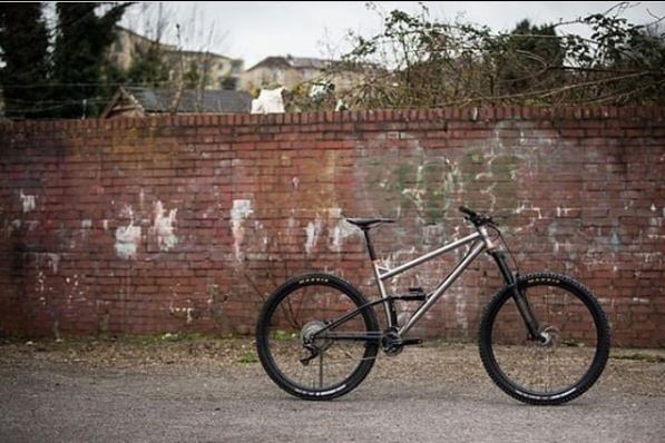 mountain bike on road against brick wall