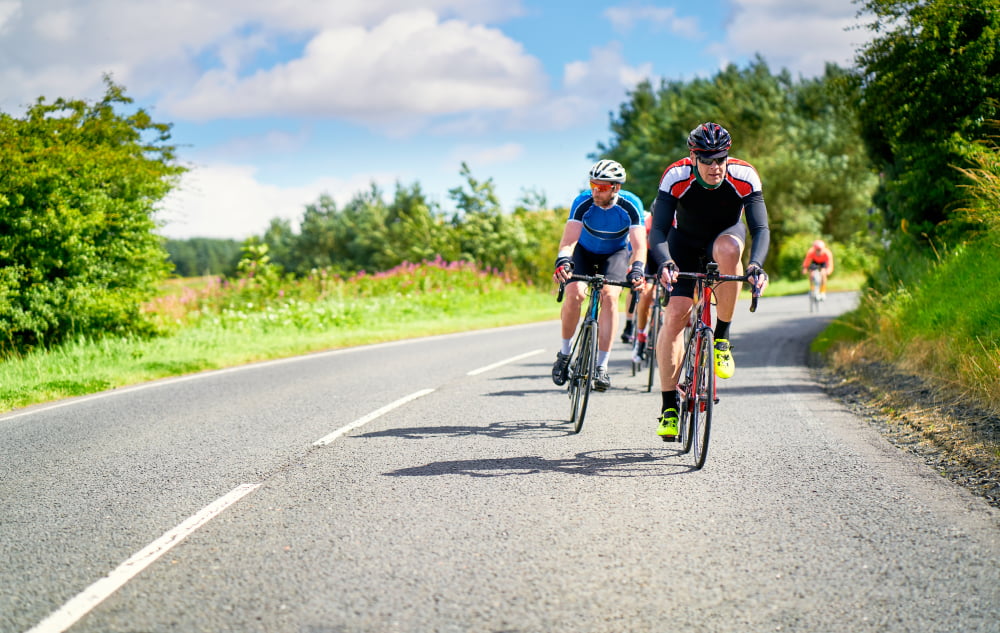 road cyclists riding on country roads on a sunny day